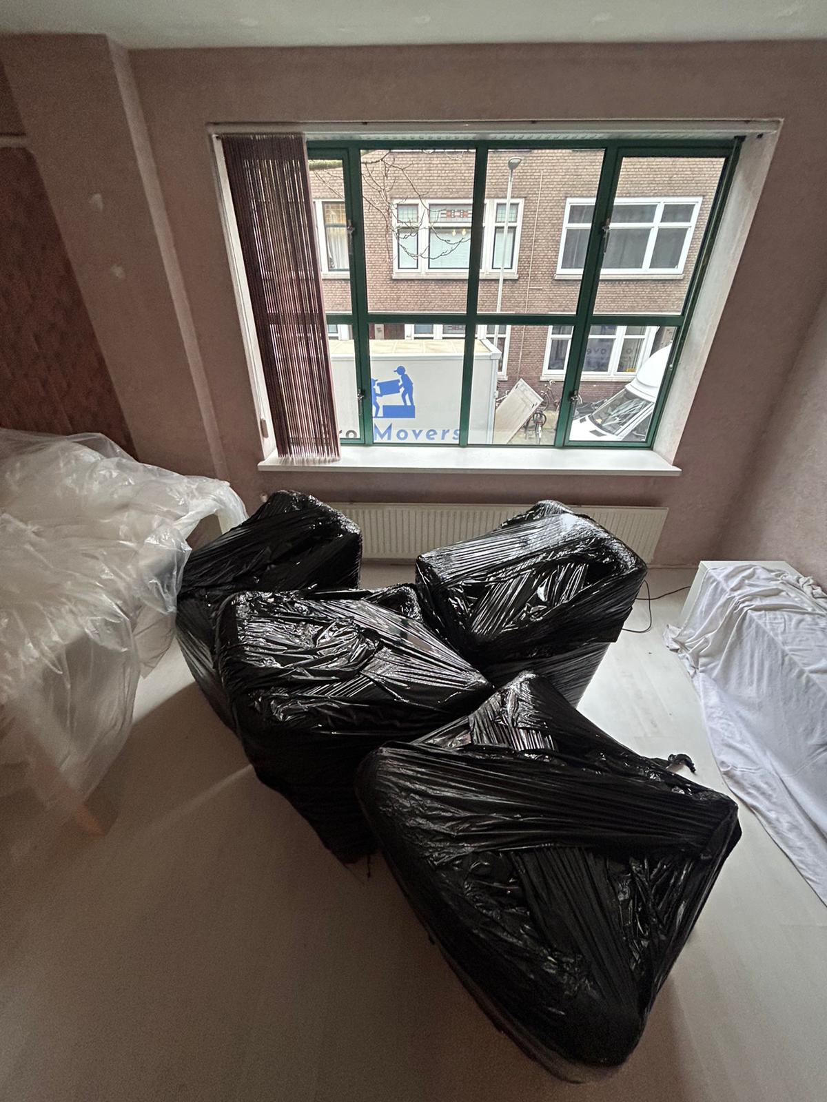 Een verhuizer van ProfMovers draagt zorgvuldig ingepakte meubels